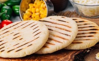 Arepa lista para rellenar en medio de comida.