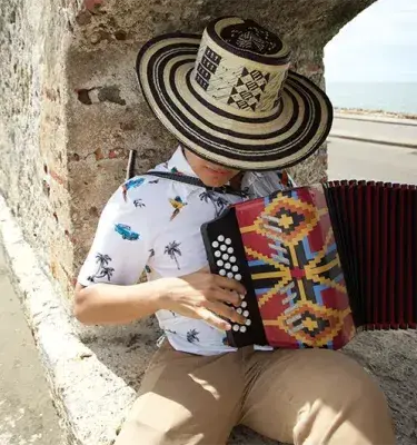 Young man wearing a Vueltiao hat and playing the accordion in Cartagena.
