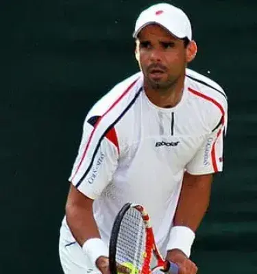 Alejandro Falla en cancha de tenis concentrado antes de un saque