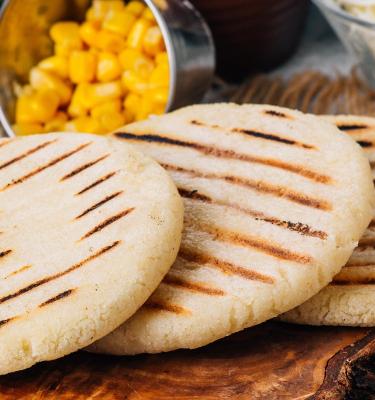 Arepa lista para rellenar en medio de comida.