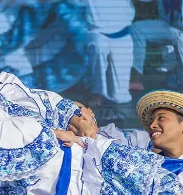 Colombian folk dancers in white and blue costumes performing