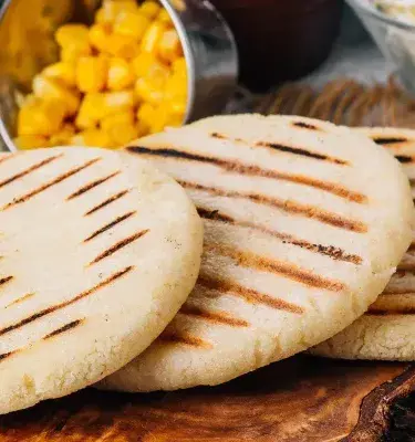 Arepa lista para rellenar en medio de comida.