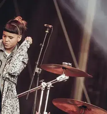 Cantante de Bomba Estéreo con abrigo de leopardo en el escenario.