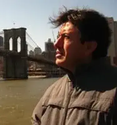 Hombre mirando al horizonte junto al puente de Brooklyn