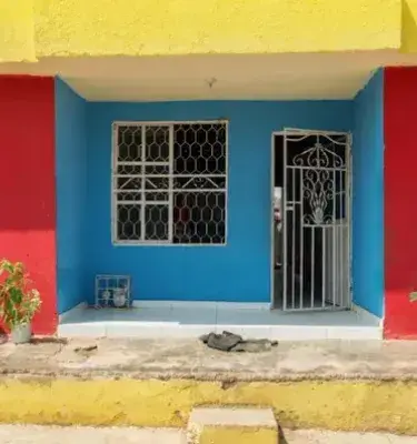 Colorful house with red walls, yellow roof and blue door