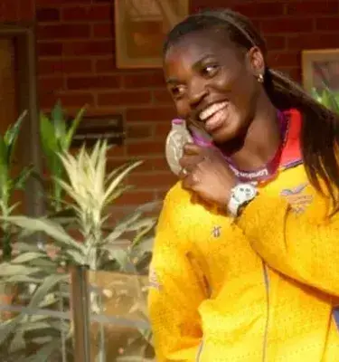 Catherine Ibargüen sonríe y muestra con orgullo su medalla