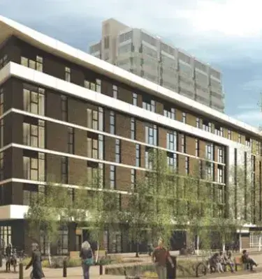 Edificio moderno rodeado de árboles y personas caminando en zona urbana verde