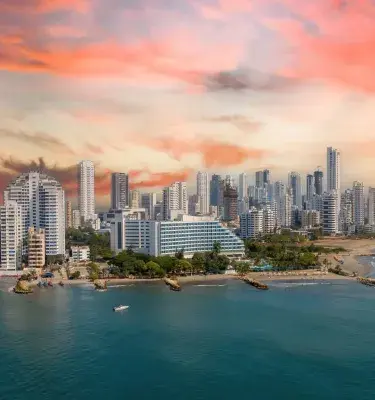 vista aérea de la costa de Cartagena con edificios altos y un cielo colorido.