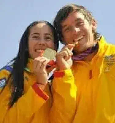 Deportistas colombianos con medallas de oro celebrando su victoria con orgullo