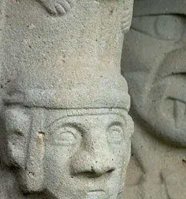 Busto de piedra gris con corona tallada.