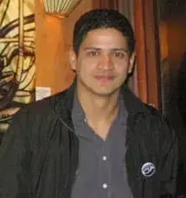 Retrato de Felipe Chiquito con chaqueta negra en interior decorado