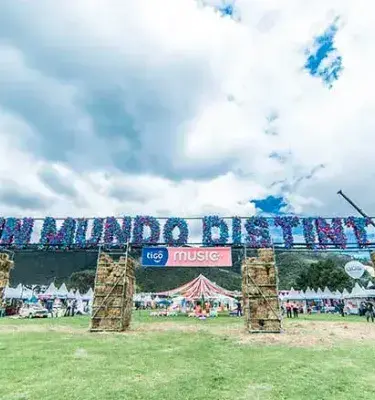 Festival (A Different World): Large sign reading “A DIFFERENT WORLD” at an outdoor festival.