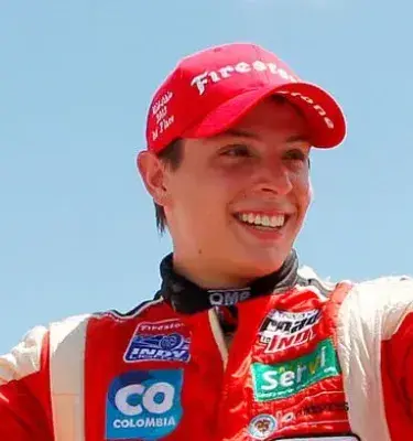 El piloto Gabby Chaves celebra con gorra roja y un trapo amarillo.