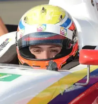 Pilotando un coche de carreras, Gabby Chaves lleva un casco con la bandera colombiana.