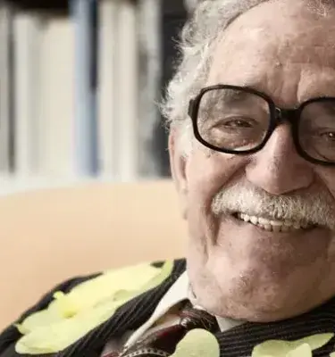 Retrato de Gabriel García Márquez sonriendo con gafas y bigote.