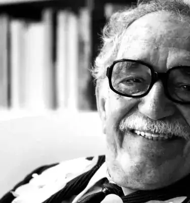 Black and white portrait of writer Gabriel García Márquez smiling.