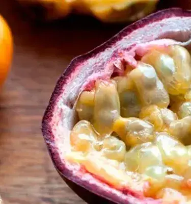 Fruta de gulupa colombiana abierta sobre mesa de madera