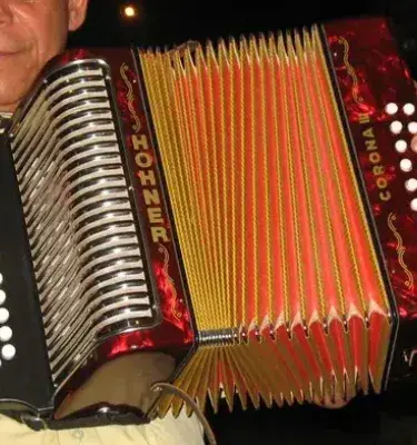 Hombre tocando un acordeón Hohner Corona. ¡Qué buen instrumento! 