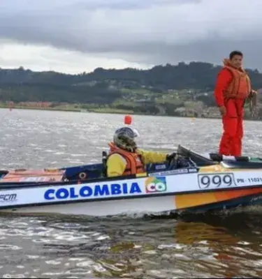 Lancha de carreras "Colombia" en el agua con dos tripulantes.