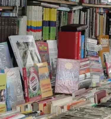 A table full of secondhand books at an outdoor market.