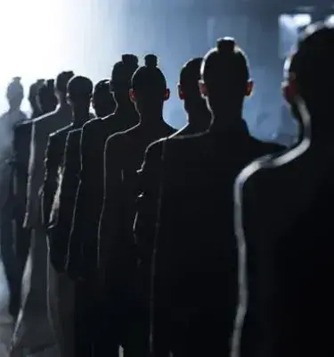 Modelos desfilando en pasarela iluminada desde el fondo