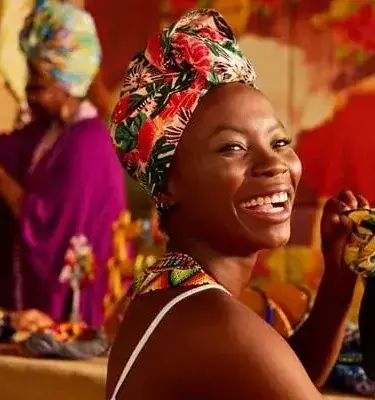  Smiling Afro-Colombian woman with colorful turban in handicraft workshop