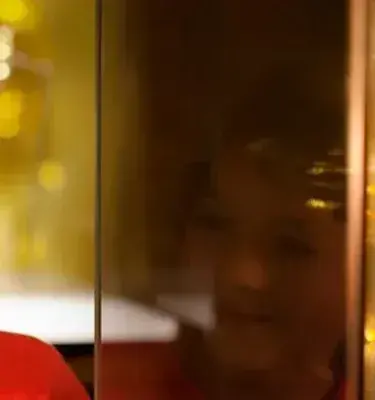 Child observing a pre-Columbian golden figure in a display case.