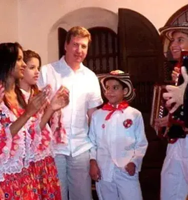 Niños y niñas vestidos con trajes típicos interpretando música vallenata con acordeón y palmas
