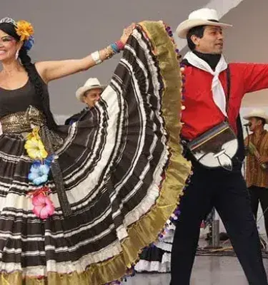 Couple dancing a folk dance in colorful traditional costumes.