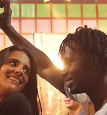 Pareja feliz bailando en un ambiente festivo con luz cálida
