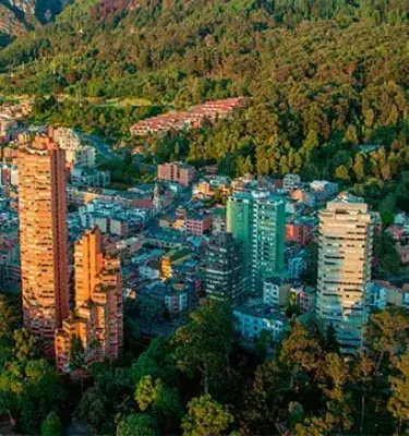 Vista aérea de Bogotá con Plaza de Toros y edificios cerca montaña.