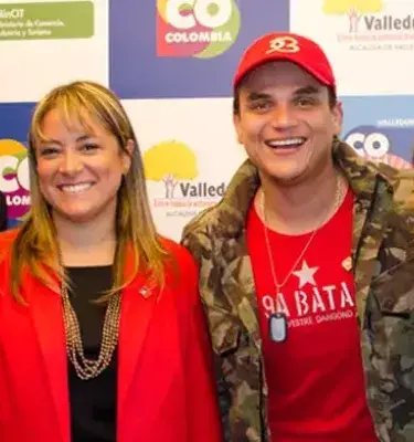 Cuatro personas, dos hombres y dos mujeres, posando y sonriendo frente a un fondo.