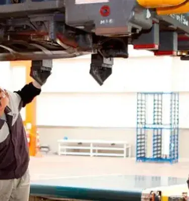 Trabajadores inspeccionando maquinaria industrial en una planta de fabricación
