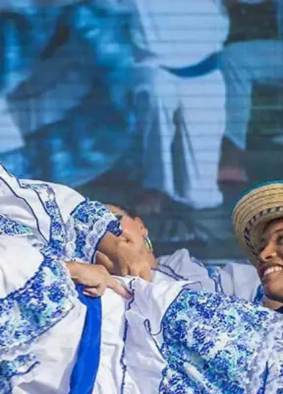 Colombian folk dancers in white and blue costumes performing