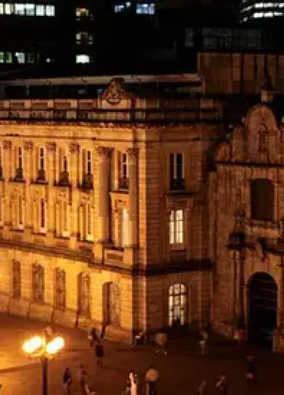 Vista nocturna de edificio colonial iluminado en Bogotá