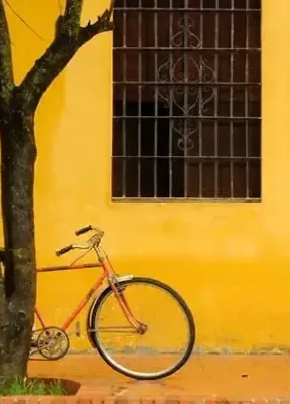 Bicycle next to yellow wall on colonial street