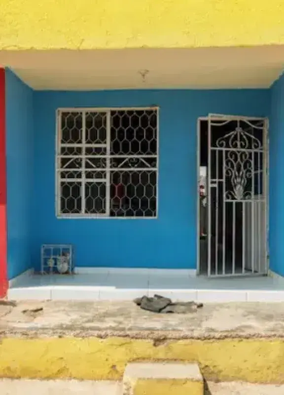 Colorful house with red walls, yellow roof and blue door