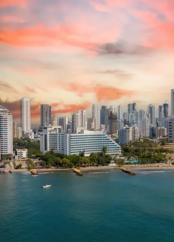 vista aérea de la costa de Cartagena con edificios altos y un cielo colorido.