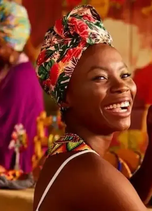  Smiling Afro-Colombian woman with colorful turban in handicraft workshop