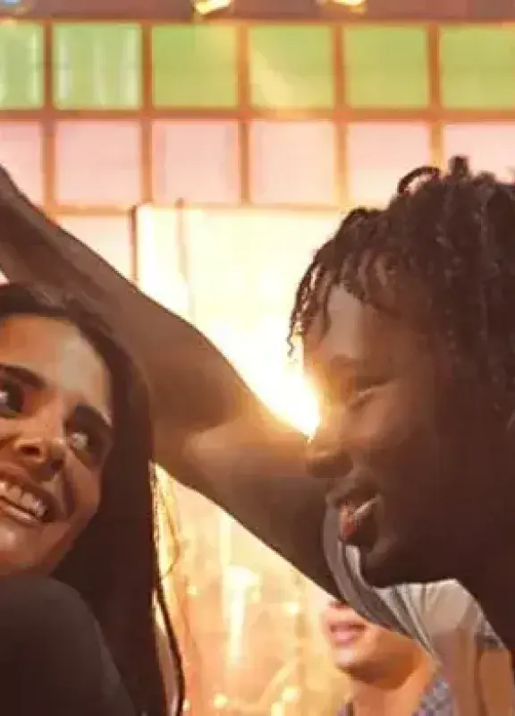 Pareja feliz bailando en un ambiente festivo con luz cálida