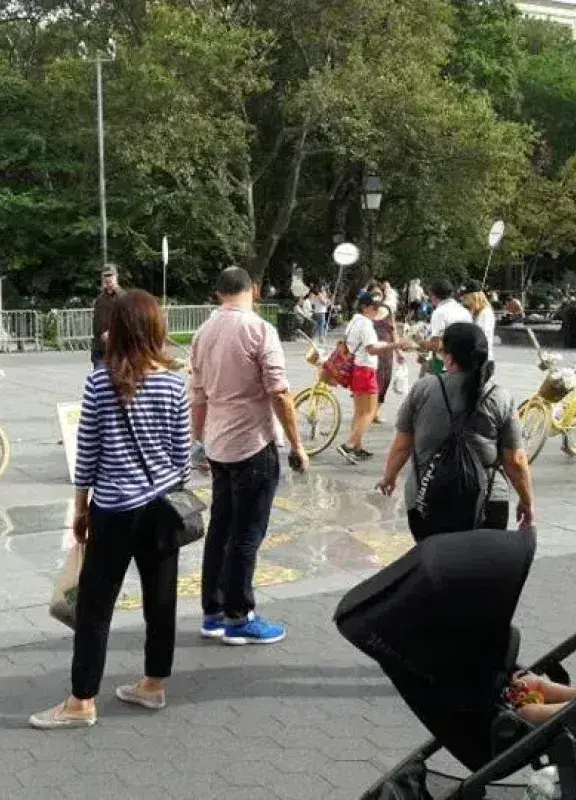 Personas en plaza interactuando con bicicletas amarillas de Colombia en paz
