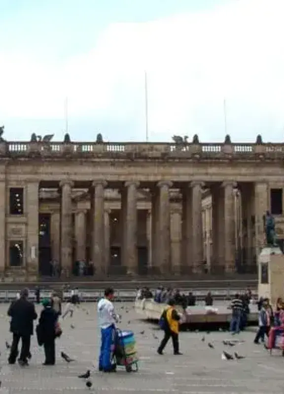 Personas caminando en la Plaza de Bolívar frente al Capitolio Nacional en Bogotá