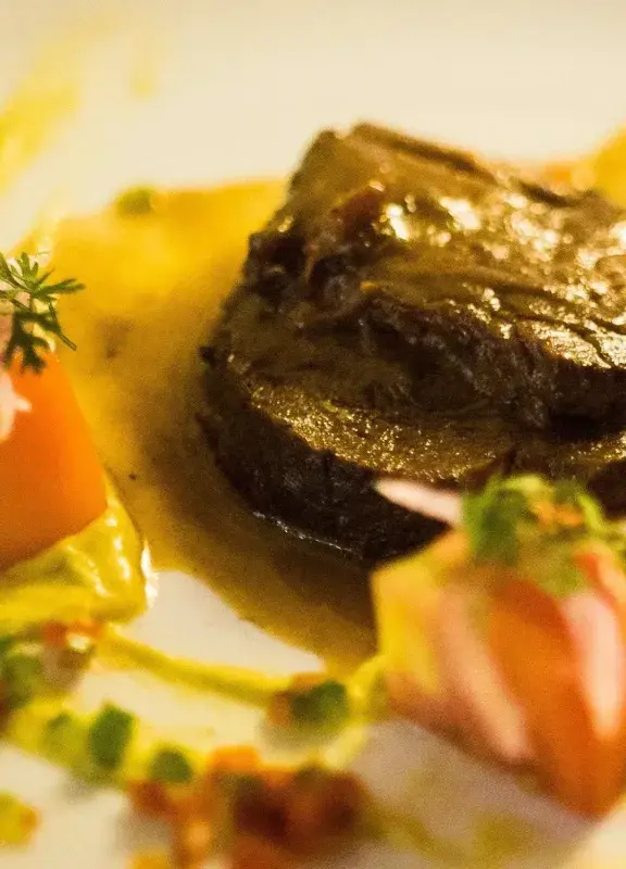 posta negra cartagenera con pure y guarniciones en plato gourmet