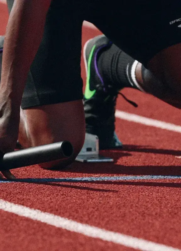 Atleta en posición de salida para carrera en pista de atletismo.