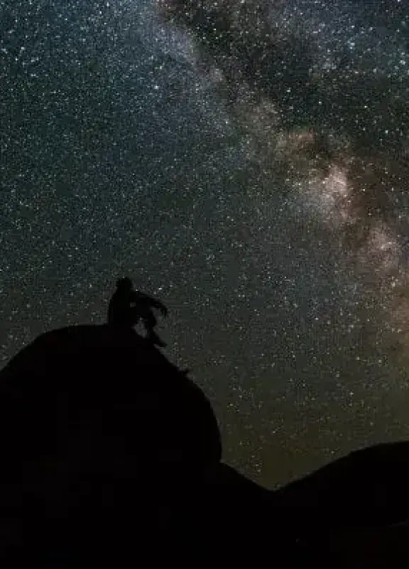 Silueta de persona observando la Vía Láctea en la noche. ¡Espectacular vista del cielo nocturno!