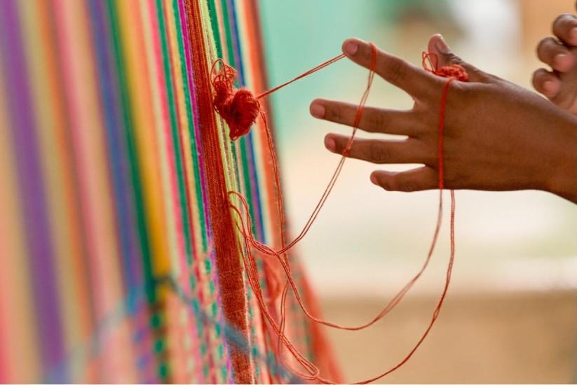 Manos tejiendo artesanía Wayuu