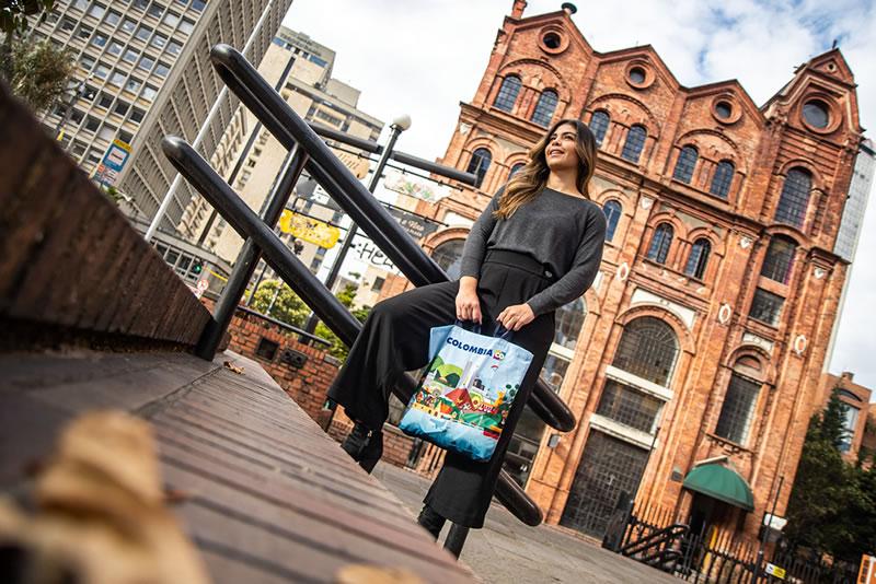 Mujer con bolsa de productos de Marca País