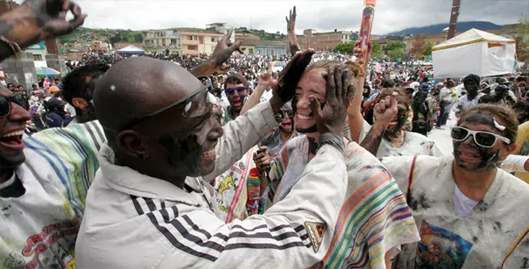 Personas se pintan el rostro con alegría en el carnaval de negros y blancos.