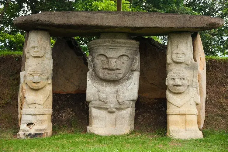 Pre-Columbian stone sculptures under a large slab in San Agustín Archaeological Park.