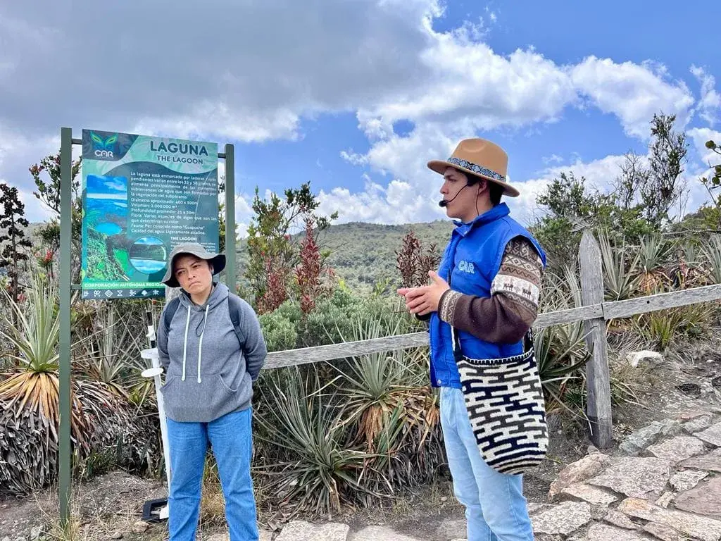 Guía explicando sobre la Laguna de Chingaza a una visitante.